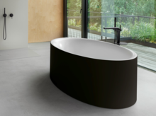 Freistehende, ovale Badewanne aus Stahl-Email in modernem Badezimmer mit großer Fensterfront und bodenstehender Armatur.